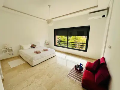 a bedroom with a bed and a large window at Family Palms Luxe Villa Marrakech with Private Pool in Marrakech