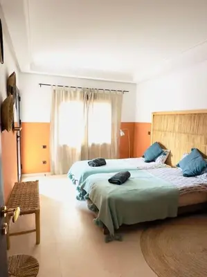 a bedroom with two beds and a window at Appartement centre Guéliz avec terrasse spacieuse in Marrakech