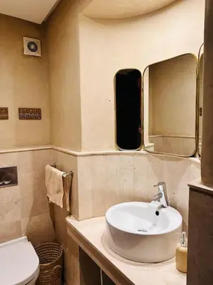 a bathroom with a sink and a mirror and a toilet at Appartement centre Guéliz avec terrasse spacieuse in Marrakech