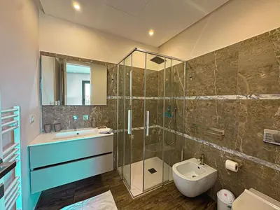 a bathroom with a shower and a sink and a toilet at Villa LEONARDO Piscine & Rooftop Terrase in Marrakech