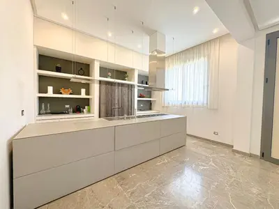 a large kitchen with white cabinets and a large window at Villa LEONARDO Piscine & Rooftop Terrase in Marrakech