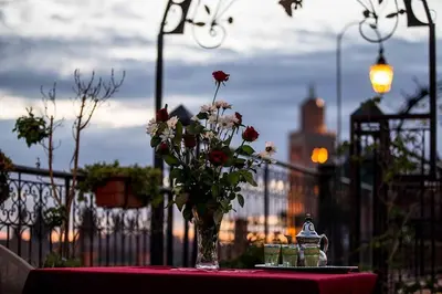 a vase of flowers on a table with a red table cloth at Hotel Ichbilia فندق اشبيلية in Marrakech