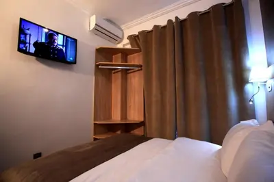a bedroom with a bed and a flat screen tv at Hotel Ichbilia فندق اشبيلية in Marrakech