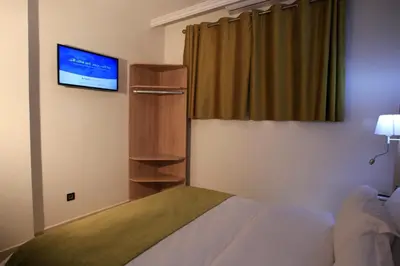 a hotel room with a bed and a tv at Hotel Ichbilia فندق اشبيلية in Marrakech