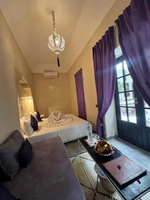 a bedroom with two beds and a table and a chandelier at Riad Sapphire & Spa in Marrakech