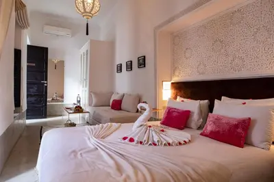 a bedroom with a large white bed with red pillows at Riad Sapphire & Spa in Marrakech