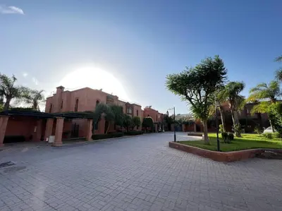 a cobblestone street with buildings and palm trees at The Majestic Marrakesh Villa 2 in Marrakech