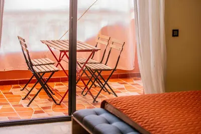 a table and chairs in a room with a window at Apartamento Residencia Kasbah de Marrakech 1 Gueliz in Marrakech