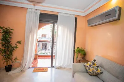 a living room with a couch and a large window at Apartamento Residencia Kasbah de Marrakech 1 Gueliz in Marrakech