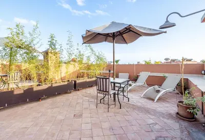 a patio with a table and chairs and an umbrella at Luxury Villa 6 ROOMS with Pool - Marrakech Center in Marrakech