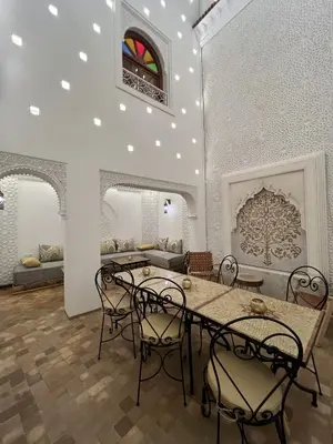 a room with a table and chairs and a couch at Riad Dar Yammi in Marrakech