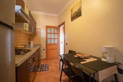 a kitchen with a table and some chairs in a room at A stunning 2 bedroom Hivernage in Marrakech