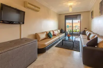 a living room with a couch and a flat screen tv at A stunning 2 bedroom Hivernage in Marrakech