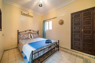 a bedroom with a bed and a window and a door at Riad Résidence Al Qaria Assiyahia Riad 22 in Marrakech