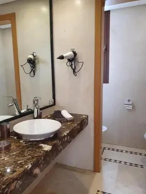a bathroom with a sink and a mirror at Vizir Center Appartements in Dar Caïd Layadi