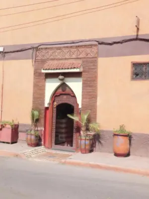 a building with potted plants on the side of a street at Riad BAHIA in Marrakech