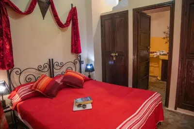 a bedroom with a red bed with a red blanket at Riad BAHIA in Marrakech
