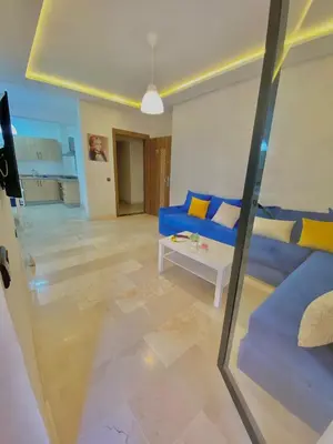 a living room with a blue couch and a table at Appartement avec piscine en face à la gare gueliz in Marrakech