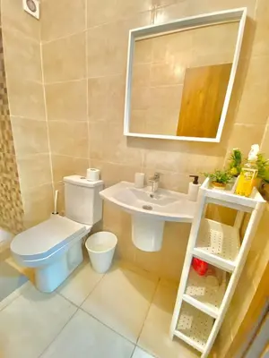 a bathroom with a toilet and a sink and a mirror at Appartement avec piscine en face à la gare gueliz in Marrakech