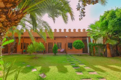 an exterior view of a house with palm trees at Le Palais Averroes - Adults Only in Marrakech