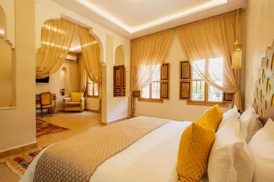 a bedroom with a large white bed with yellow pillows at Le Palais Averroes - Adults Only in Marrakech