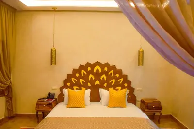 a bedroom with a large bed with yellow pillows at Le Palais Averroes - Adults Only in Marrakech