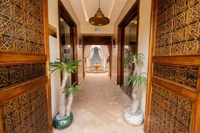 a hallway with two palm trees in vases at Le Palais Averroes - Adults Only in Marrakech