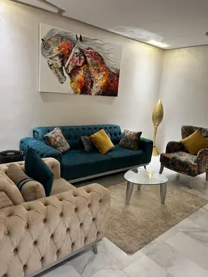 a living room with a blue couch and a painting of a horse at Appart avec Piscine, Riad Garden in Marrakech