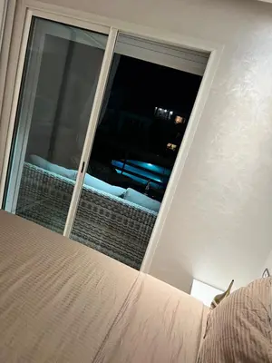 a bedroom with a window with a view of a bed at Appart avec Piscine, Riad Garden in Marrakech