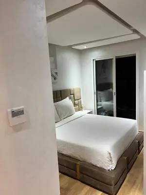 a bedroom with a large white bed and a window at Appart avec Piscine, Riad Garden in Marrakech