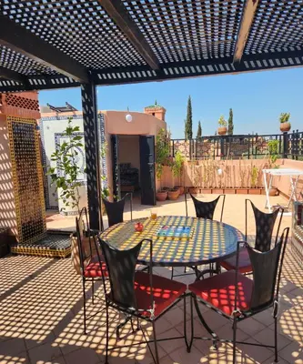 a patio with a table and chairs on a deck at Tres joli Apparemment atlas golf rosort by marwa € ilyes in Marrakech