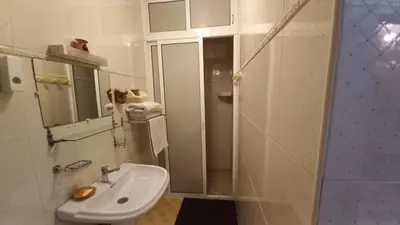 a white bathroom with a sink and a shower at Stay with low budget in Marrakech