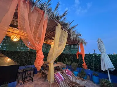 a patio with a table and chairs and an umbrella at RIAD FOUZIA in Marrakech