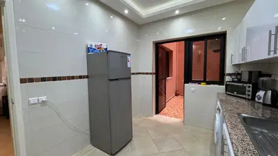 a kitchen with a refrigerator in the middle of a room at Magnifique appartement Marrakech in Marrakech