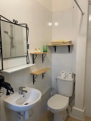 a white bathroom with a toilet and a sink at Riad Hanya in Marrakech