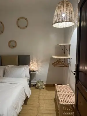 a bedroom with a bed and a table and a chandelier at Riad Hanya in Marrakech