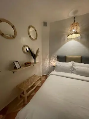 a bedroom with a white bed and two mirrors at Riad Hanya in Marrakech