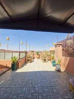 a patio with potted plants and lights on a roof at Riad Hanya in Marrakech