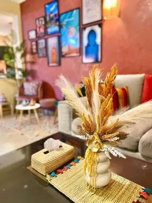 a living room with a vase with feathers on a table at Appartement Marrakech Hivernage N54 RESIDENCE CAPRICE PALACE in Marrakech