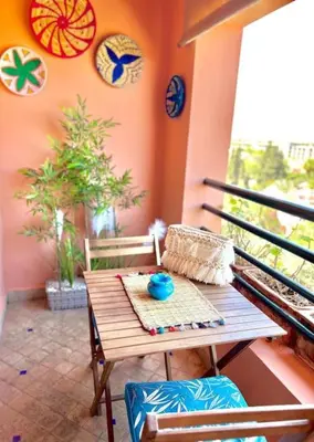 a wooden table and chairs on a balcony at Appartement Marrakech Hivernage N54 RESIDENCE CAPRICE PALACE in Marrakech