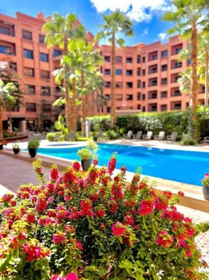 a bunch of flowers in front of a swimming pool at Appartement Marrakech Hivernage N54 RESIDENCE CAPRICE PALACE in Marrakech