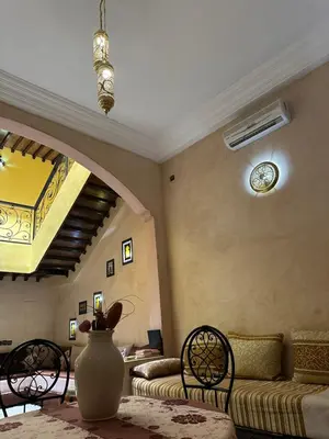 a living room with a couch and a vase on a table at Riad Majestic Marrakech in Marrakech