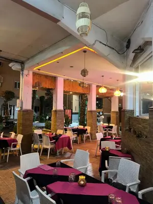 a restaurant with tables and chairs with purple table cloth at Riad Majestic Marrakech in Marrakech