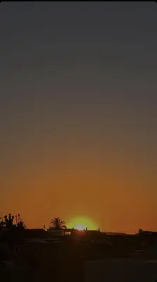 a sunset with the sun setting in the horizon at Riad Majestic Marrakech in Marrakech