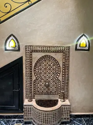 a bathroom with a tiled shower in the corner of a room at Riad Majestic Marrakech in Marrakech