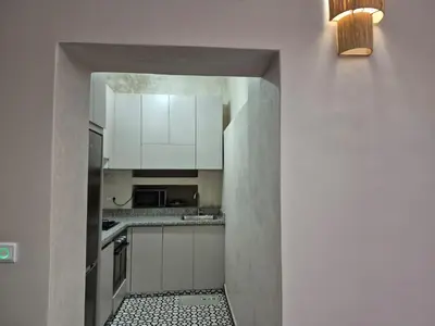 a small kitchen with white cabinets and a doorway at Riad l'Empire in Marrakech