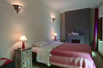 a bedroom with a bed and two lamps and a fireplace at RIAD PRIVATISÉ 3 Chambres 6 Personnes Place Jemma El Fna in Marrakech