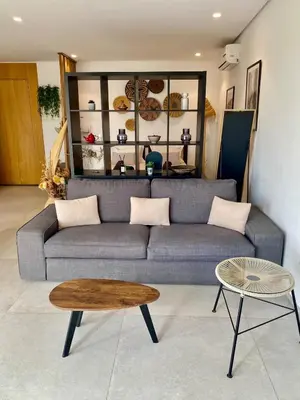 a living room with a couch and a table at STUDIO MODERNE PROCHE MACDO RTE CASA in Marrakech