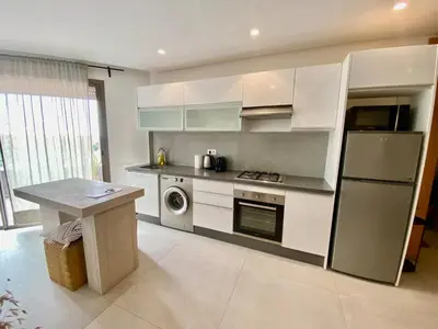 a kitchen with a refrigerator and a table in it at STUDIO MODERNE PROCHE MACDO RTE CASA in Marrakech