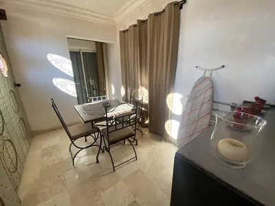 a kitchen with a table and chairs in a room at Bel appartement en centre-ville avec piscine in Marrakech